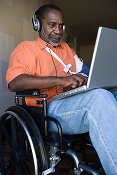 elderly man in wheelchair with a laptop